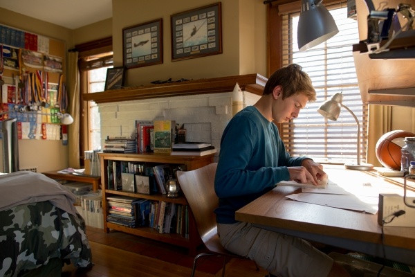 young man study at college dorm room desk