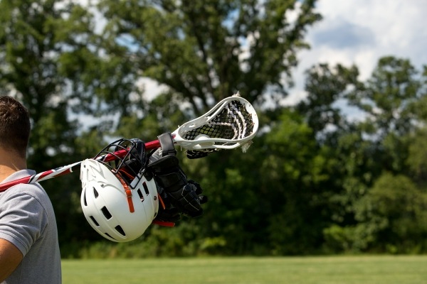 child holding lacrosse equipment