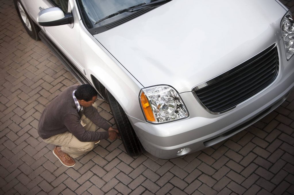 man checking tire pressure