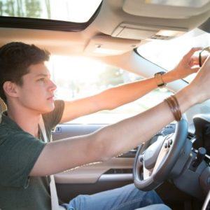 Teenage boy adjusting rear view mirror