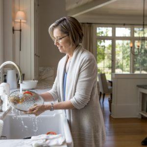 woman washing dishes in the kitchen sink