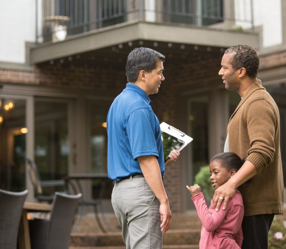 Inspector talking to father and daughter outside home