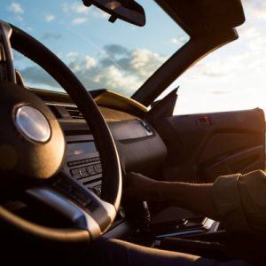 Close up of steering wheel and dashboard of a convertible while light shines in