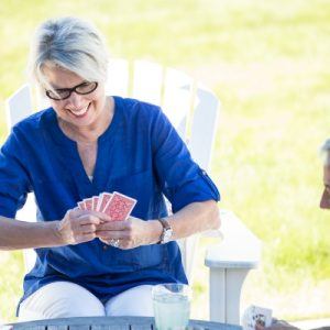 older woman playing cards outside