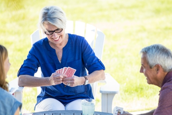 older woman playing cards outside