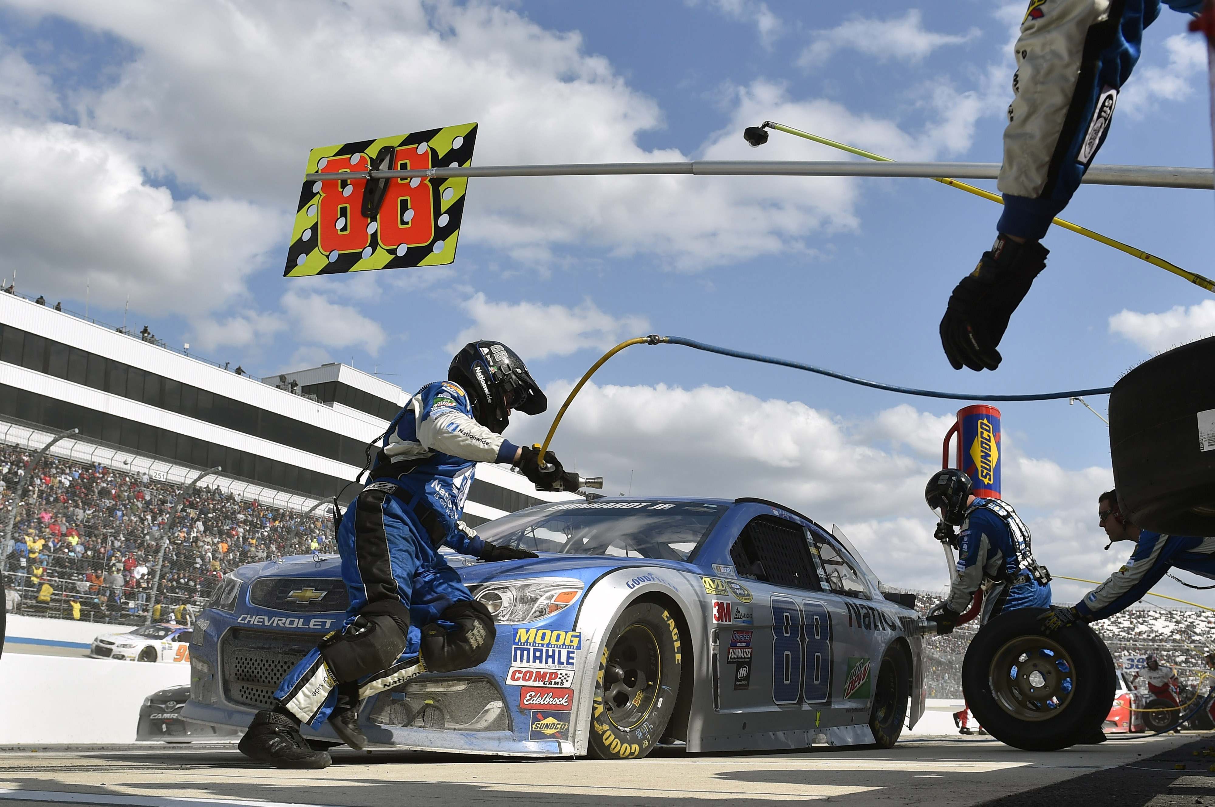 pit crew replacing tires on a race car