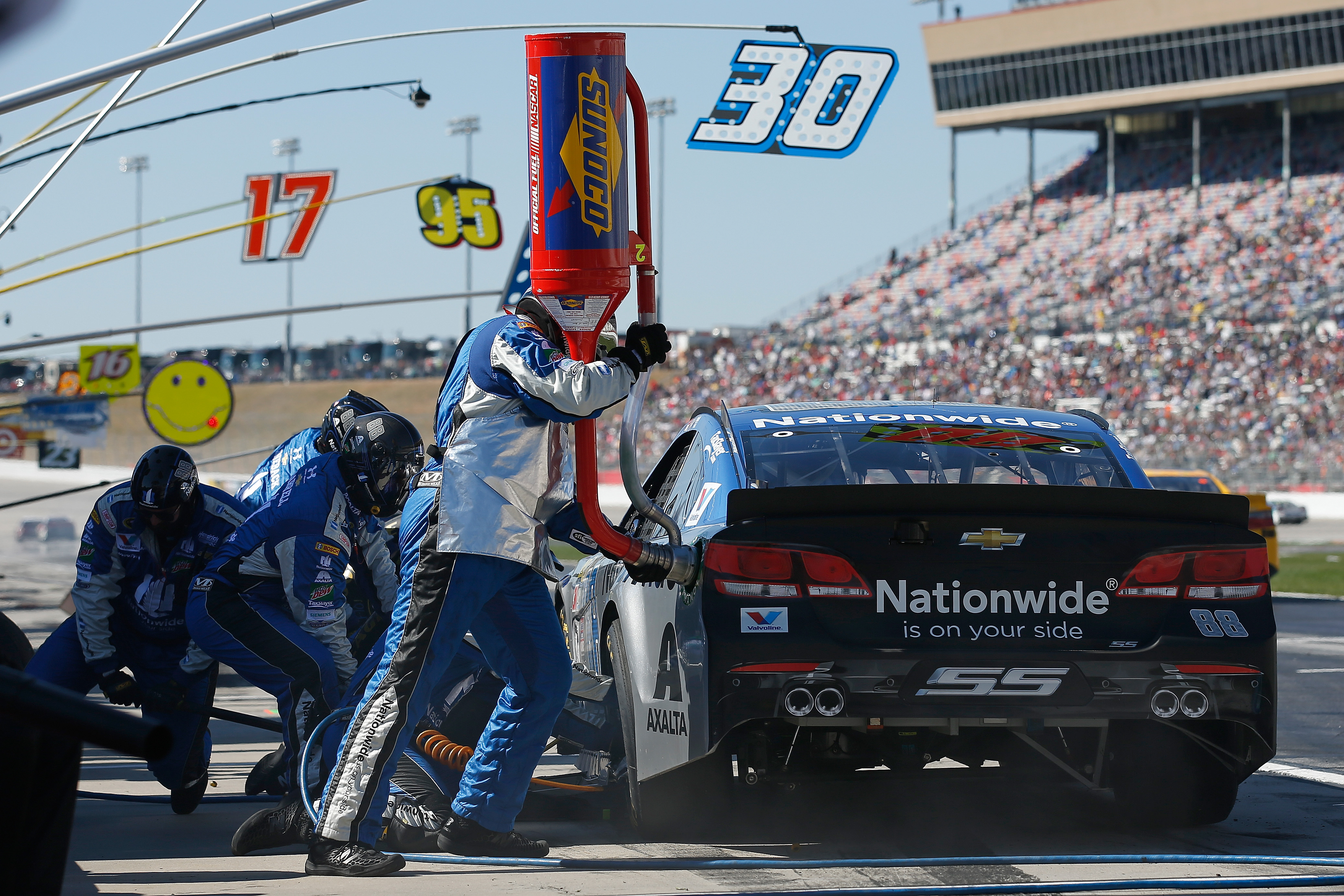 pit crew putting gas in a race car