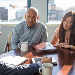 Couple discusses finances at a table with their advisor