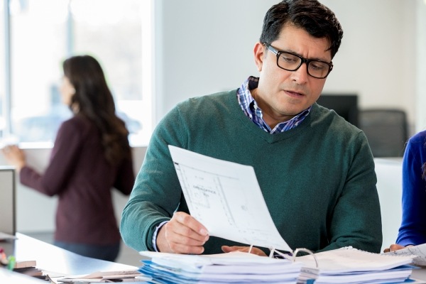 Man with glasses reviewing financial document