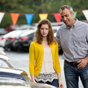 Young woman and father at a car lot