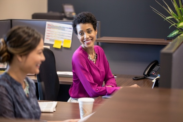 women smiling at their desks