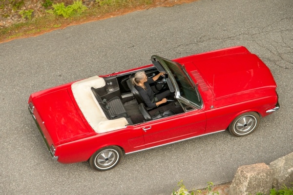 woman driving classic red mustang convertible