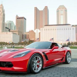 red sports car in front of city skyline