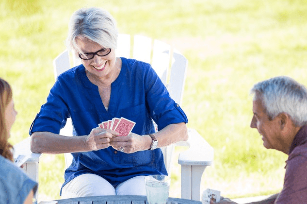 Woman playing cards outside at senior apartment