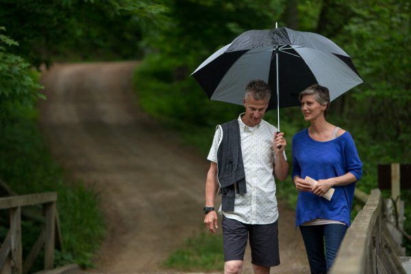 couple walking holding umbrella