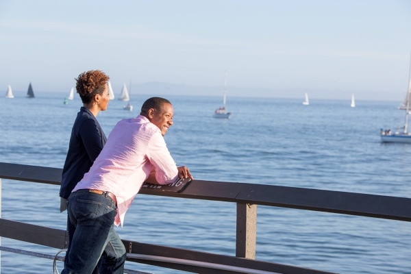 two people looking out into the ocean from a pier