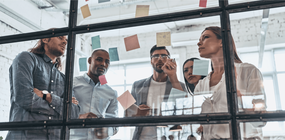 coworkers gathering around post it notes