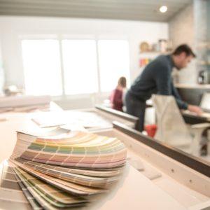 man on a laptop behind a paint color wheel