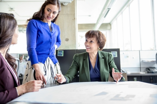 three women talking at a desk