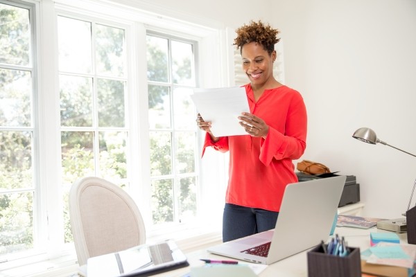woman in red shirt smiling at papers