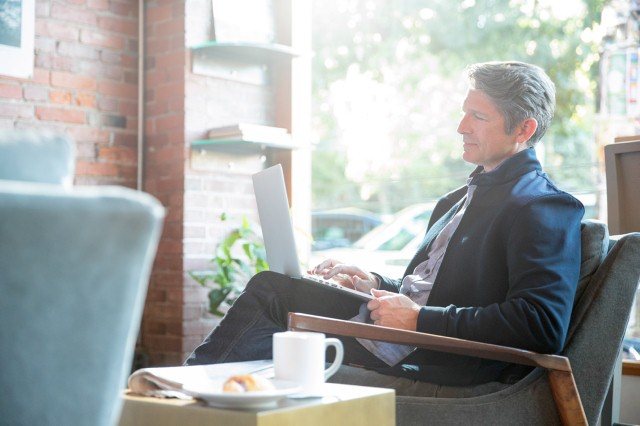 a man working on his laptop in a coffee shop