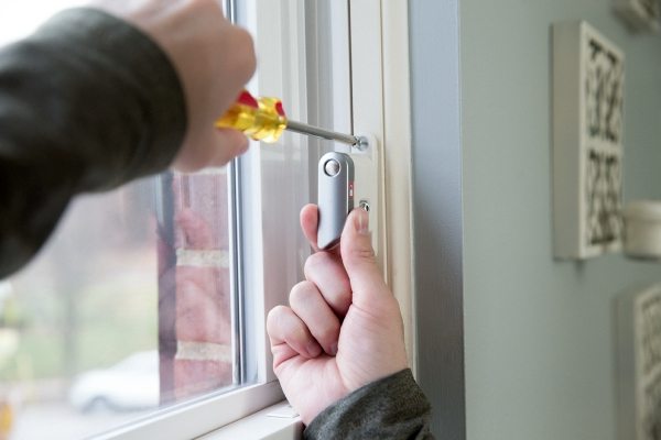 a person using a screwdriver on a window frame