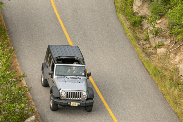 Jeep driving down a winding road
