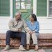 Couple sitting on the front steps of their home