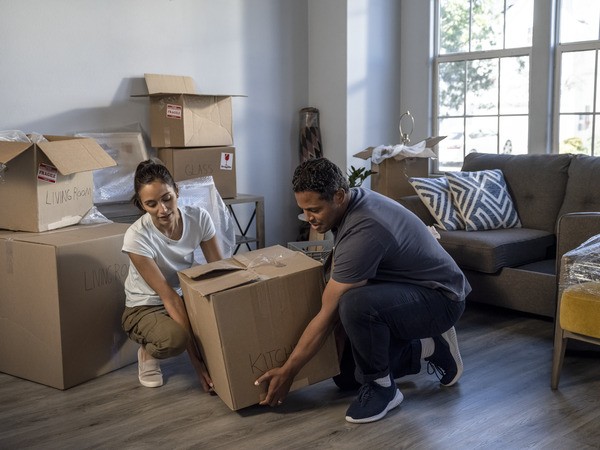 Couple picking up moving box