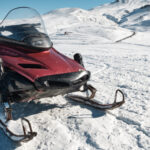 A snowmobile parked on the snow.