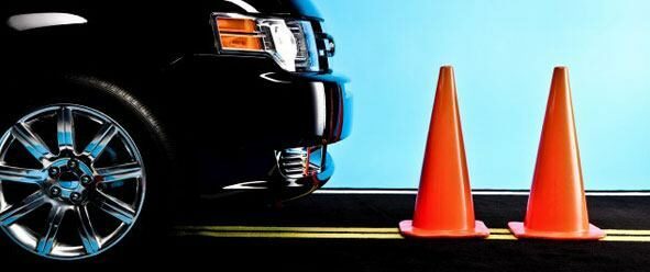 a black car in front of orange cones