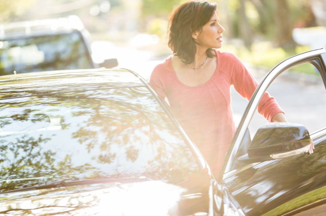 a woman getting into her car