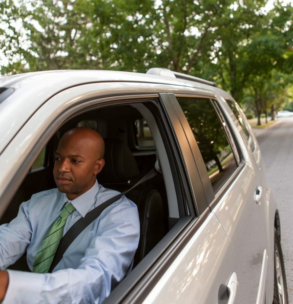 man wearing tie driving car