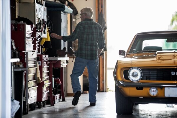 a man and a yellow car in a garage