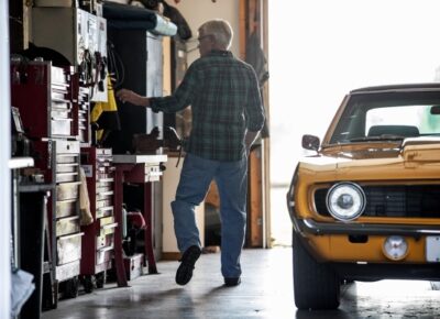 a man and a yellow car in a garage