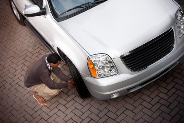 man fixing car tire