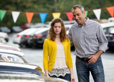Young woman and father at a car lot