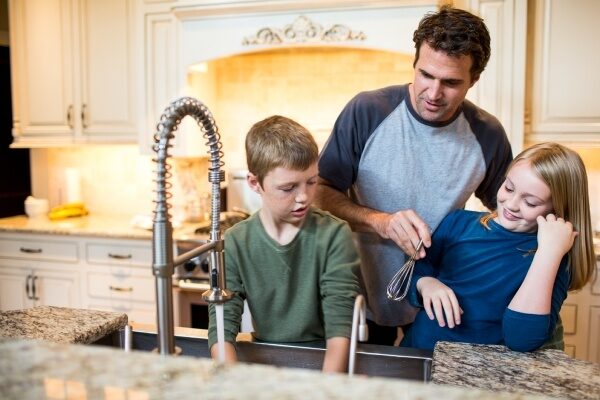 Family washing up at their kitchen sink