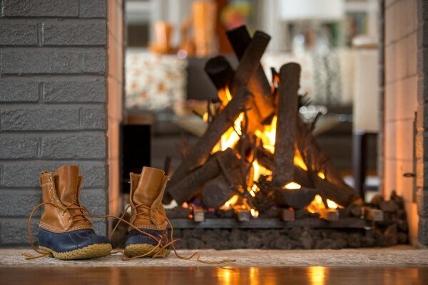duck boots in front of a modern fireplace
