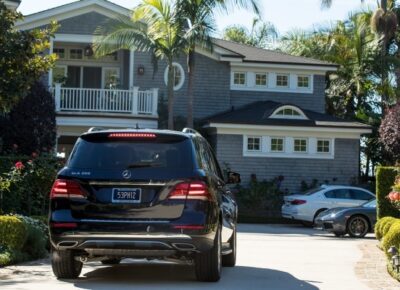 Black SUV parked in front of big house