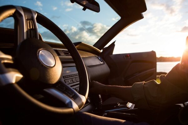 Close up of steering wheel and dashboard of a convertible while light shines in