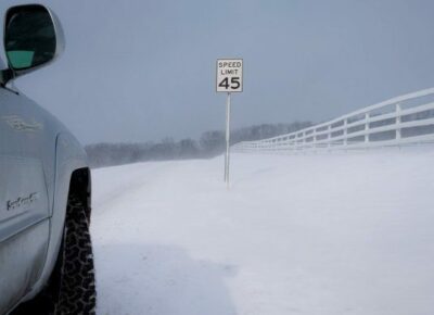 SUV on snow covered road with a 45 mph speed limit sign