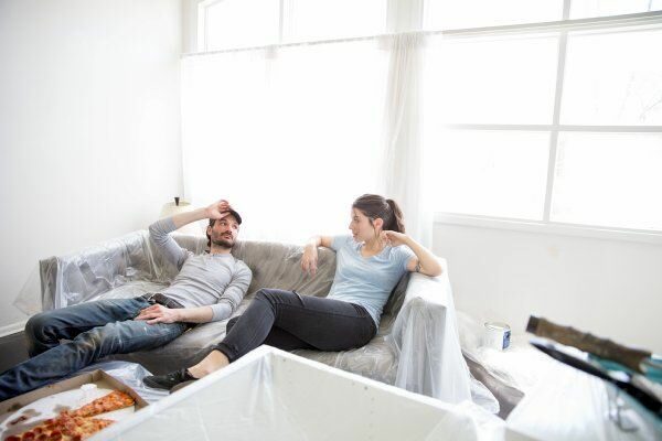 couple sitting on couch after painting house