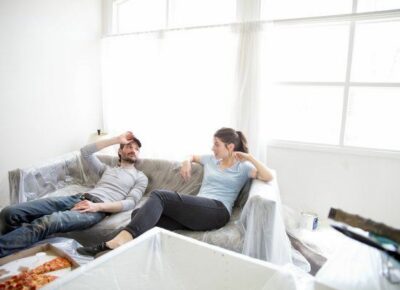 couple sitting on couch after painting house