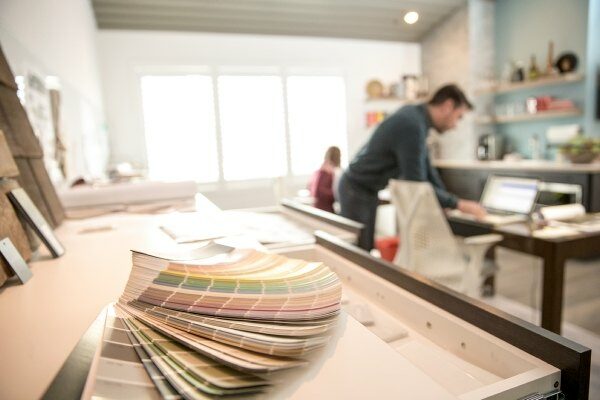 man on a laptop behind a paint color wheel