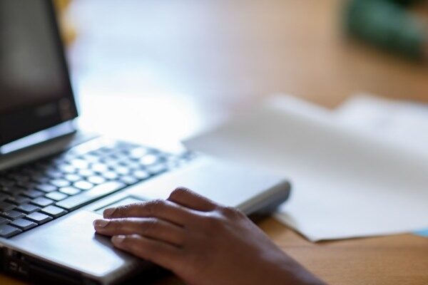 a hand on a laptop computer