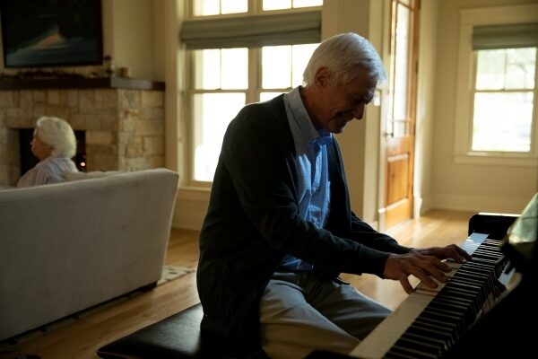 elderly man playing a piano