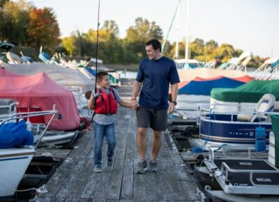 Father and son walking on a boating dock