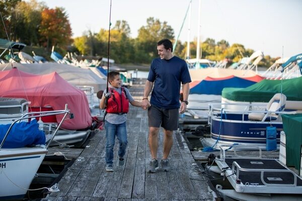 Father and son walking on a boating dock