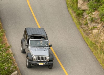 Jeep driving down a winding road